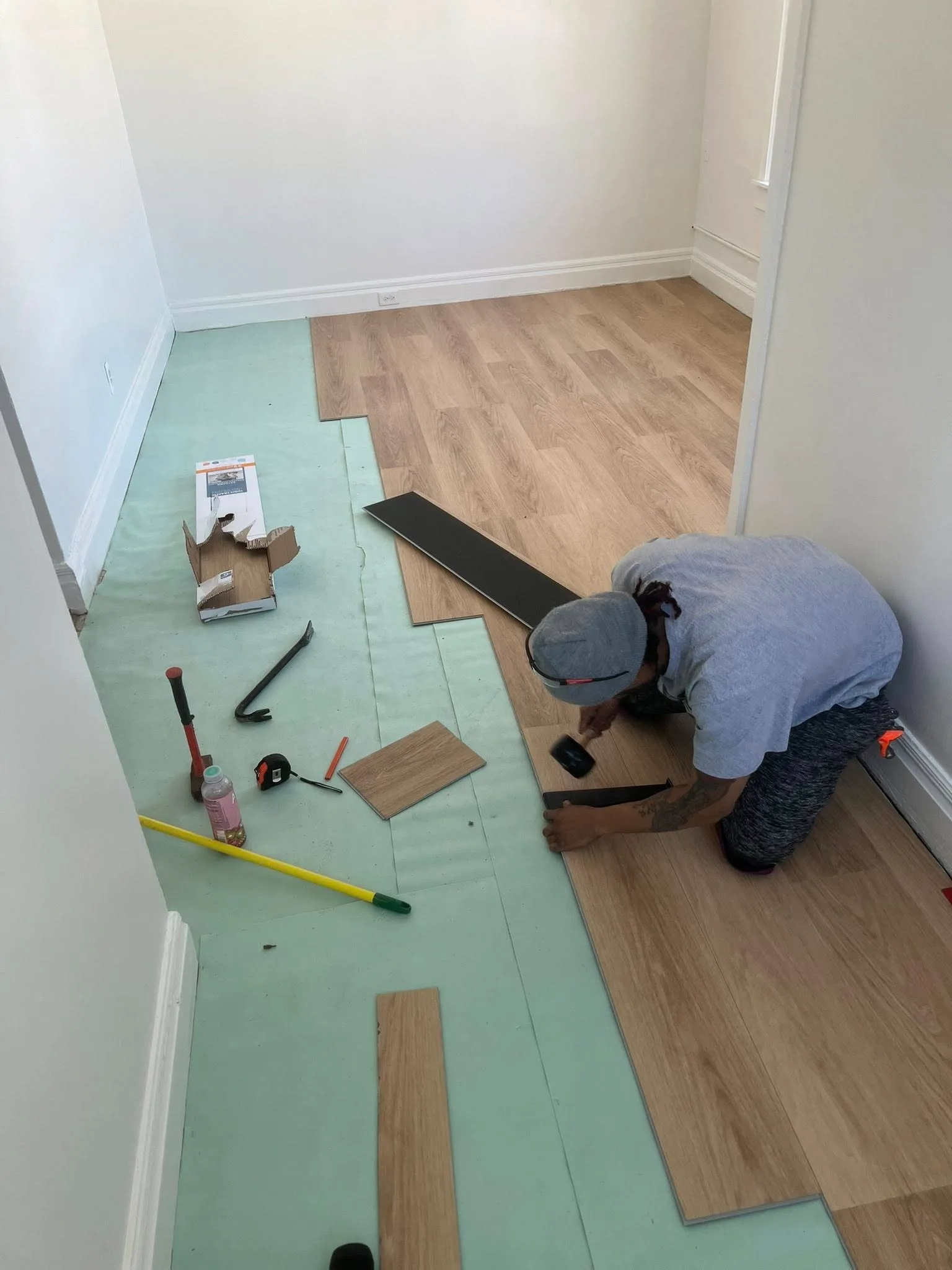 Installing vinyl plank flooring on a Detroit-area job.
